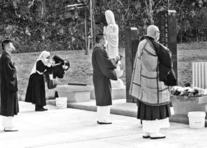 旧大川小学校で行われた追悼式の様子をカメラ撮影するシティ・マグフィラさん(左から2人目)=11日、宮城県石巻市(市原幸彦撮影)