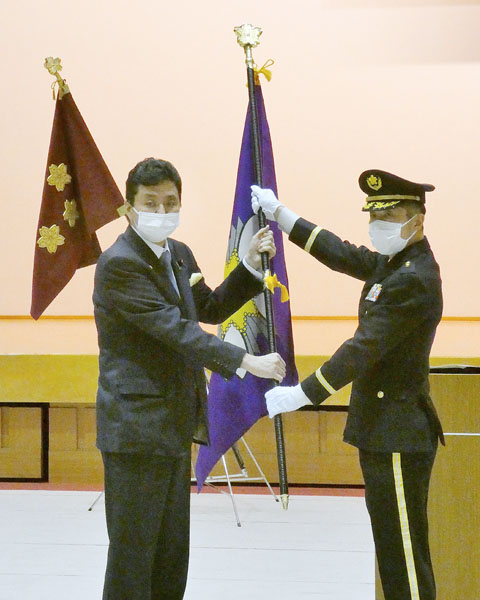 発足したサイバー防衛隊の隊旗授与式で、木村顕継司令(右)に隊旗を手渡す岸信夫防衛相(当時)=3月17日午前、防衛省