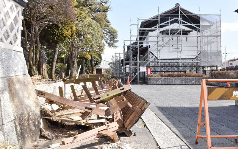 地震で崩れた郷土資料館の塀（左）。右奥は昨年２月の地震で被害を受け、修復中の建物＝２１日午前、宮城県角田市