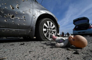 １２日、キエフ郊外イルピンで、銃弾を浴び放置された乗用車と人形（ＡＦＰ時事）