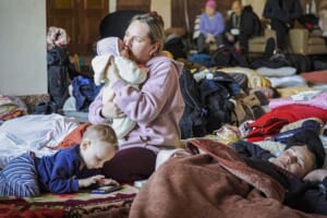 １１日、ウクライナ西部リビウの鉄道駅で、戦禍を逃れようと子供を抱え列車を待つ女性（ＥＰＡ時事）