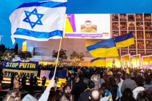 ２０日、テルアビブの広場に集まり、ウクライナのゼレンスキー大統領のイスラエル国会での演説を聞く人々（ＡＦＰ時事）