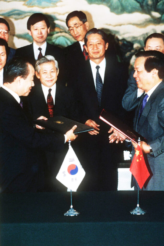 中韓国交文書を署名後、文書を交換する銭其琛中国 外相(右手前)と李相玉韓国外相(左手前)=1992年、北京(AFP時事)