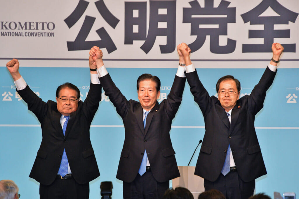 公明党全国大会で手を取り合う山口那津男代表(中央)、斉藤鉄夫新幹事長(同右)ら =30日午後、東京都内のホテル