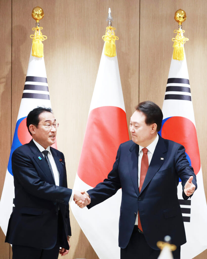 7日、ソウルで、握手する岸田文雄首相（左）と韓国の尹錫悦大統領（時事）